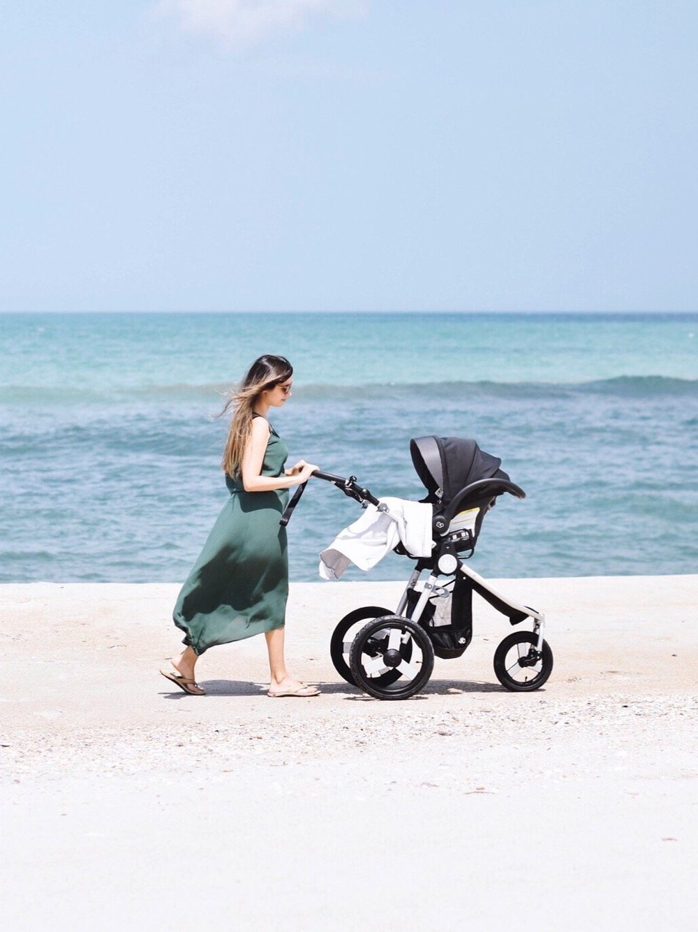 Photo of Natalie Kay of Sustainably Chic with her Bumbleride Speed jogging stroller and Nuna Car Seat with Bumbleride Indie Car Seat Adapter Attached