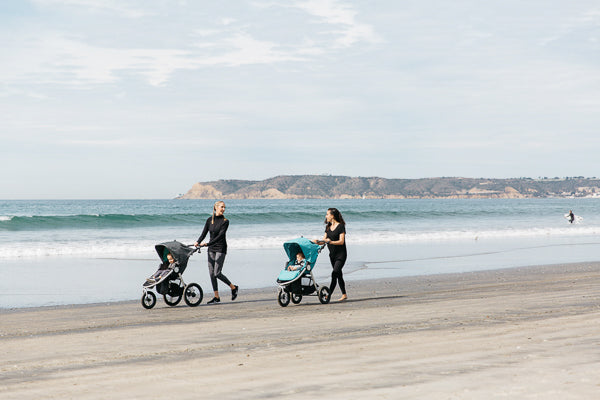 Picture of two mothers walking with their Bumbleride strollers on the beach