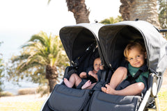 Picture of multiple children sitting inside Indie Twin double stroller in Dusk. Global