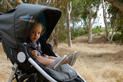 Closeup of child smiling sitting inside IRONMAN stroller by Bumbleride