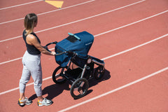 Picture of mother getting ready to run on soft running track with Bumbleride Speed jogging stroller in Supernova. New Collection 2022. Global