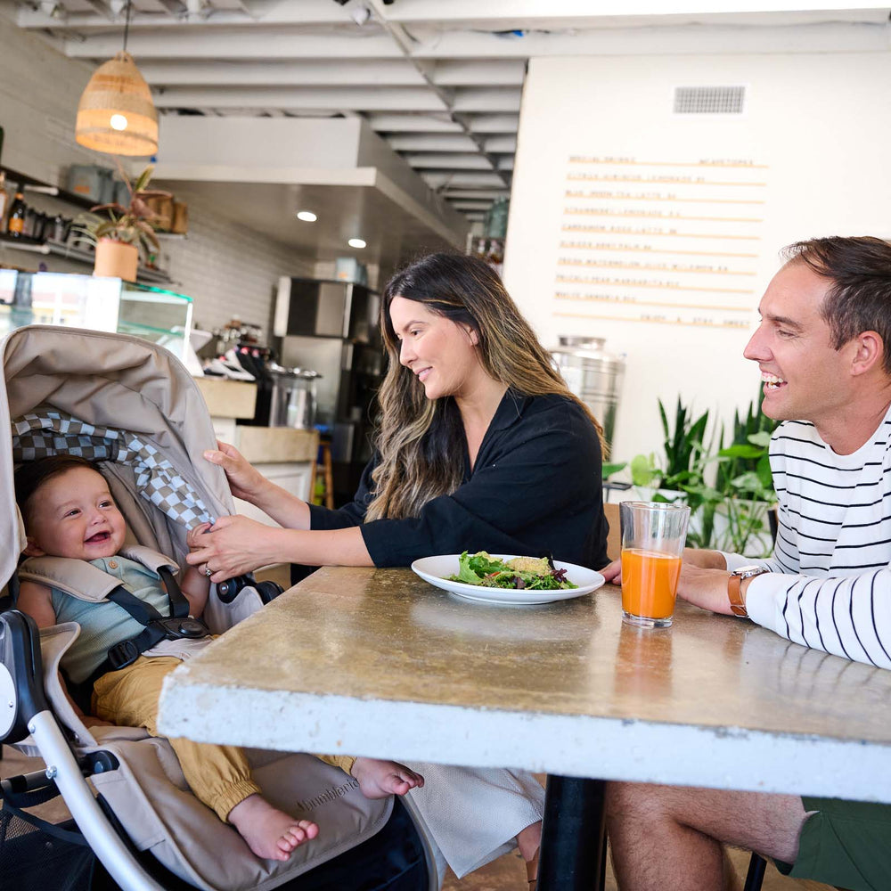 
                      
                        Mother and Father sitting at table with child sitting in Era reversible stroller in Sand - New Collection 2022 - Global
                      
                    